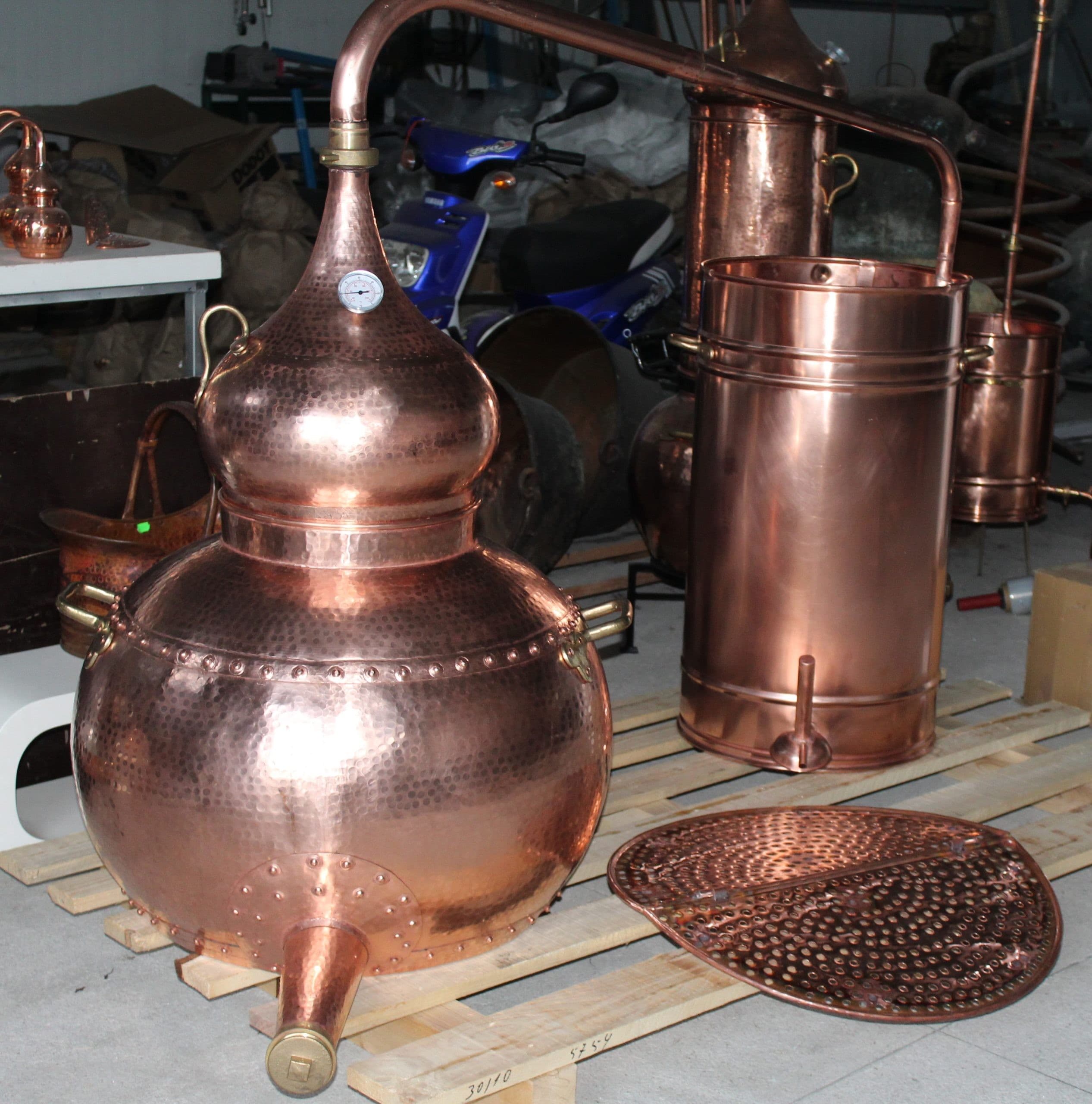 This Premium Copper Riveted alembic still is completely equipped with a copper pot, riveted union construction, a swan neck lid and a condensing recipient with serpentine coil This model is also equipped with a detachable brass locking system on the helmet lid that will facilitate storage when the alembic is not in use and also allows the connection of a refining lentil that can be purchased separately. Thermometer, drain pipe and sieve not included.